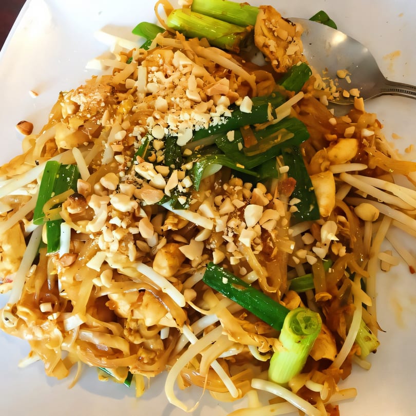 A close-up of Bangkok Corner's Pad Thai, featuring noodles, bean sprouts, green onions, and peanuts.